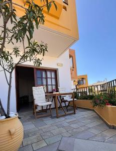 a patio with a table and chairs on a building at Menelaos Apartments in Daratso