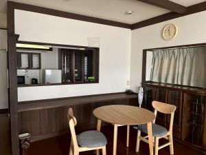 una cucina con tavolo, 2 sedie e specchio di Irest Village Matsumoto 2 a Matsumoto
