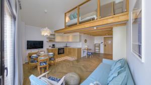 a living room with a couch and a loft at Bursztynowa Rewa, Sun & Snow in Rewa