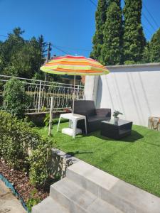 a patio with a chair and an umbrella at Kis Vitorlás in Balatonmáriafürdő