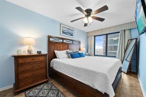 Un dormitorio con una cama y un ventilador de techo. en Island Winds West 471, en Gulf Shores
