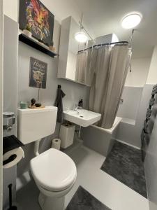 a white bathroom with a toilet and a sink at Modern Comfort in Central Hamburg 3 Room Apartment in Hamburg +22 photos