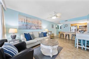 Una sala de estar con un sofá blanco y una cocina. en Island Winds West 471, en Gulf Shores 34 fotos más
