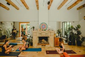 a group of people sitting in a room with a fireplace at BlissHouse Luxurious Guesthouse calm and energetic spot near by city surrounded by the forest where you will find your peace and your people in Krakow