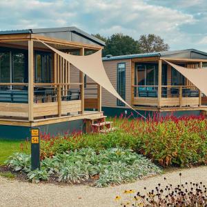 フォールトハイゼンにあるTrinity Lodges 12 peopleの庭付きポーチを囲む家