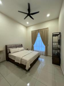 a bedroom with a bed and a ceiling fan at De Home Kluang Homestay in Kluang