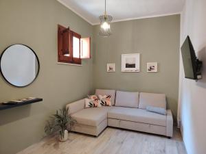 un soggiorno con un divano e uno specchio di Ovidio home a Palermo