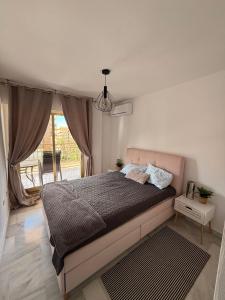 a bedroom with a bed and a large window at Playa Dona Sofia Bella in Fuengirola