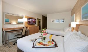 a hotel room with two beds and a desk with a tray of food at Holiday Inn Washington-Central/White House by IHG in Washington, D.C.