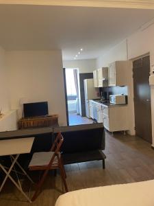 Una sala de estar con un sofá y una cocina. en Studio cosy en centre d'Ajaccio, en Ajaccio