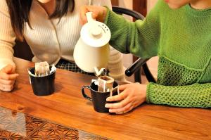 two women sitting at a table drinking coffee in mugs at Misono no Oyado - RO 美園のおやど - ろ #IO2 in Wakayama