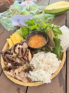 a plate of food with meat and vegetables on a table at Villa Hồ Tràm - Phòng Đơn Cozy, Hiện Đại, Thoáng Đãng in Xuyên Mộc