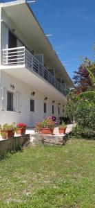 a white house with potted plants in front of it at InnJoy Space in Glyfada +22 photos