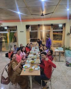 a group of people sitting at a table eating at The Pine-hill Kasauli I Restaurant I Sky Deck I Manki point view I Couple friendly I Party Events in Dharampur