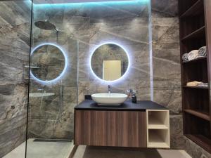 un bagno con lavandino e specchio di Сучасна квартира з терасою на морі та підземний паркінг a Odessa Altre 19 foto
