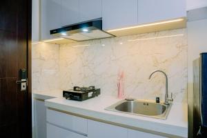 a kitchen with a sink and a stove at Pleasurable and Tidy Studio Daan Mogot City Apartment By Travelio in Jakarta