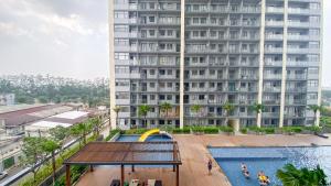 an apartment building with a swimming pool and a large building at Pleasurable and Tidy Studio Daan Mogot City Apartment By Travelio in Jakarta