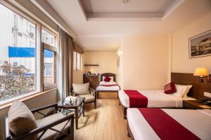 a hotel room with two beds and a window at Hotel Marshyangdi in Kathmandu