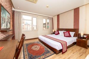 a bedroom with a large bed and a table and a desk at Hotel Marshyangdi in Kathmandu