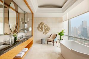 un bagno con vasca e una grande finestra di Raffles Jakarta a Giacarta