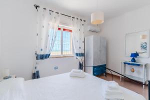 a kitchen with a white table and a window at Fronte Mare Villa Raffaele in Punta Prosciutto