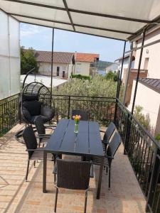 a black table and chairs on a patio with a view at Apartman Bepino terasa&parking in Pirovac
