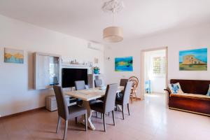 a dining room and living room with a table and chairs at Fronte Mare Villa Raffaele in Punta Prosciutto