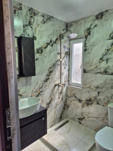 bagno in marmo con lavandino e servizi igienici di Apartment Giorgi Mazniasvhili a Batumi
