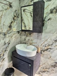un bagno con lavandino e specchio di Apartment Giorgi Mazniasvhili a Batumi Altre 32 foto