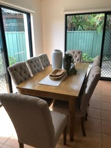 Una mesa de comedor con sillas y una mesa de madera. en Luxury 3 bedroom townhouse, stroll to beaches, en Shelly Beach