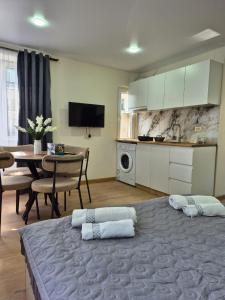 una camera con due letti e un tavolo e una cucina di Apartment Giorgi Mazniasvhili a Batumi