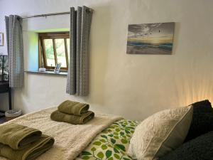 a bedroom with a bed with two towels on it at The Old Cowshed - B and B in Pembroke