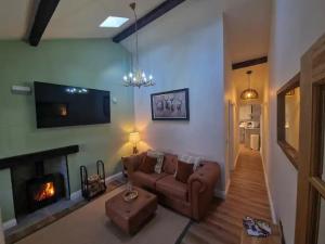 a living room with a couch and a fireplace at Gable Cottage - Staindrop - Copper Bath - Logburner in Staindrop