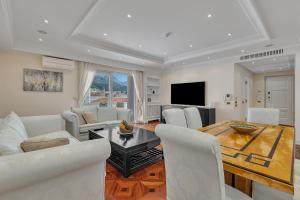 Una sala de estar con una mesa y sillas blancas. en Apartment Residence - FIRST ROW SEA - Makarska Exklusiv, en Makarska