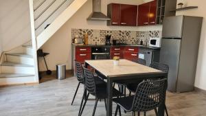 a kitchen with a table with chairs and a refrigerator at Gîte Bambou, Beauval Zoo in Seigy