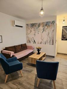 a living room with a couch and two chairs at Gîte Bambou, Beauval Zoo in Seigy