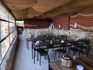 a room with tables and chairs in a restaurant at Wadi Dana Lodge - نزل وادي ضانا in Dana