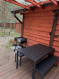 a picnic table and a bench on a deck at Leśna Chata in Kamieńczyk