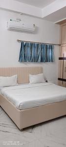 a bedroom with a large bed with a window at The Ashish Luxury Stay in Chittaurgarh