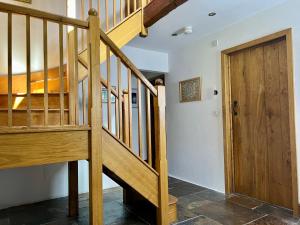 a wooden staircase in a room with a wooden door at The Old Cowshed - B and B in Pembroke