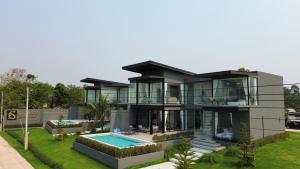 a large house with a swimming pool in front of it at Sararin Luxury Villas in Nong Khai