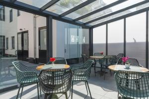 a patio with tables and chairs and windows at Petite Room With Wifi, Ac, And Shared Kitchen in Tilburg