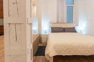 a bedroom with a white bed and two lamps at La bahia rooms in Santander +38 photos
