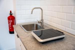 a cell phone sitting on a counter next to a sink at La bahia rooms in Santander