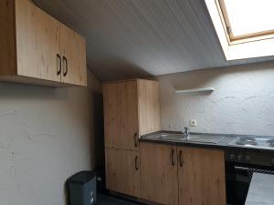 a kitchen with wooden cabinets and a sink and a window at Ferienwohnungen Maya & Lara in Losheim +31 photos