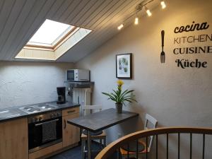 a kitchen with a stove and a table with chairs at Ferienwohnungen Maya & Lara in Losheim