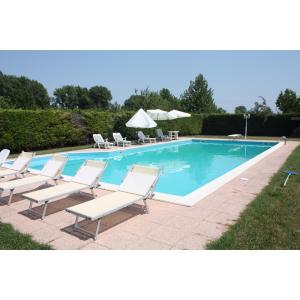 a swimming pool with lounge chairs next to it at Agriturismo Loghino Caselle in San Giorgio Di Mantova
