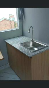 eine Küchentheke mit Spüle und Fenster in der Unterkunft Alleyway home in Ho-Chi-Minh-Stadt