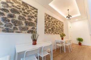 a room with two tables and chairs and a stone wall at La bahia rooms in Santander