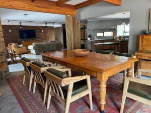 a dining room with a wooden table and chairs at Ukujabula in Groblersdal
